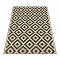 Black and beige plastic straw outdoor rug with geometric tribal pattern